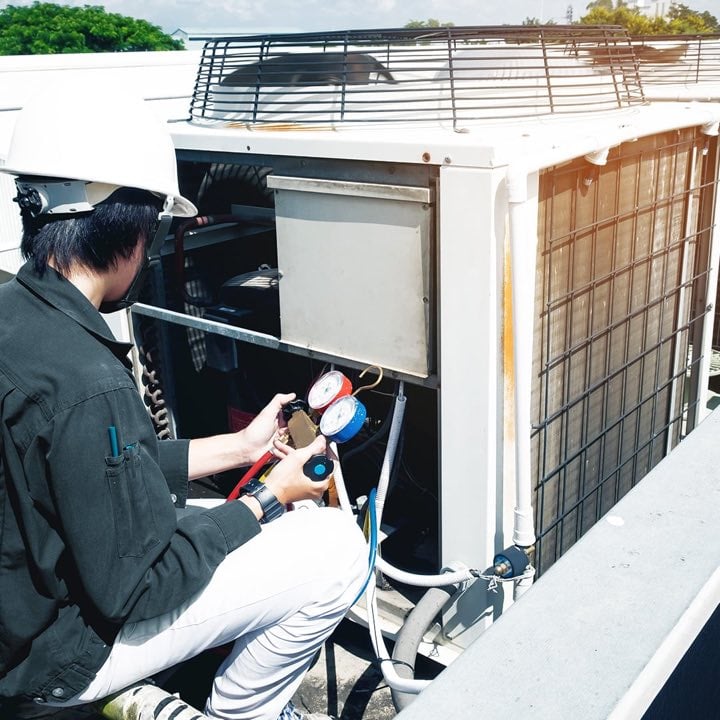 Técnico realizando manutenção em uma unidade externa